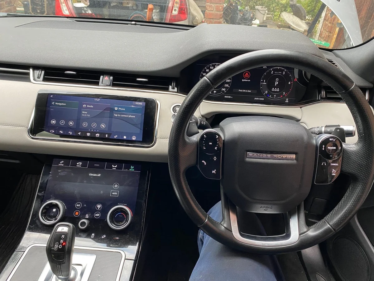 The dashboard, steering wheel and instrument cluster inside a vehicle cabin